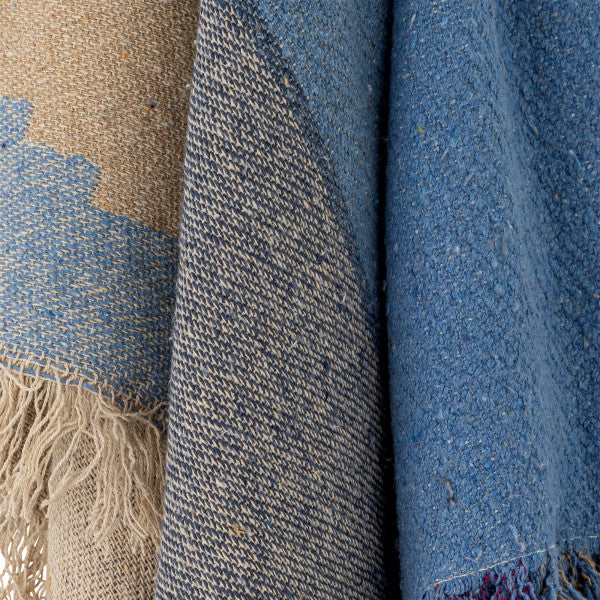 Close-up of textured fabric with fringes in blue and beige tones.