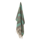 Throw blanket with tassels on a white background, with the colours white and green