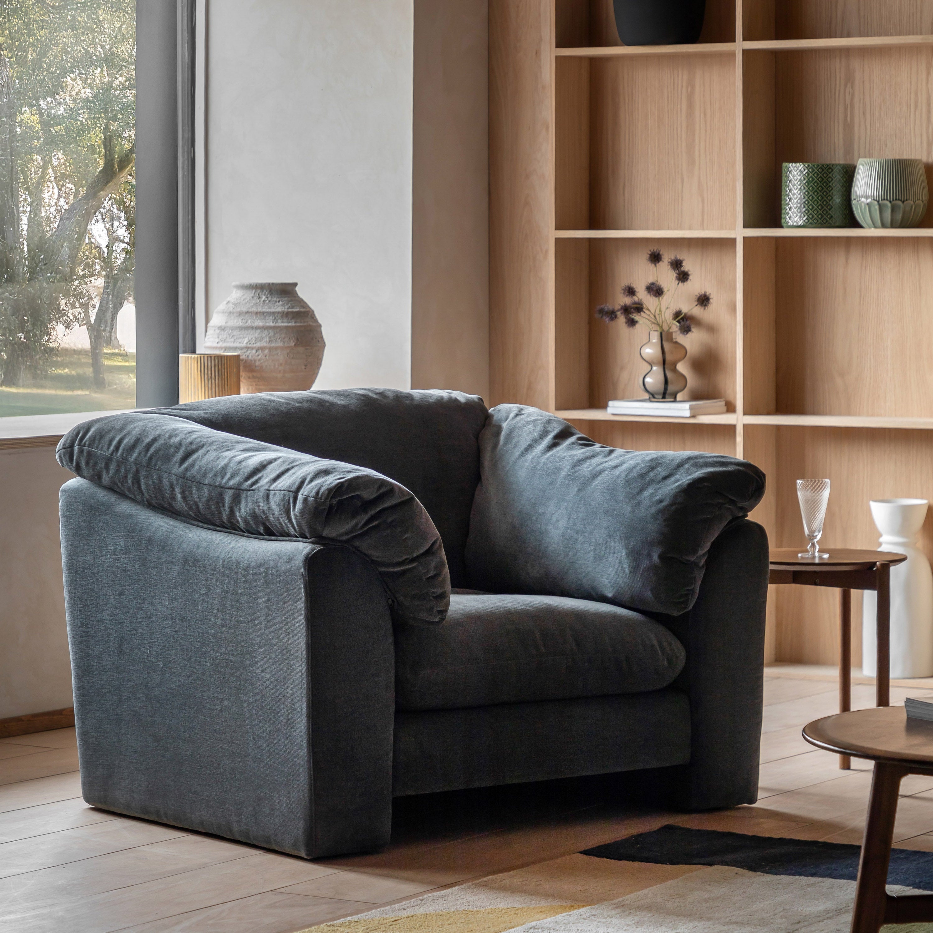 Gray sofa in a living room with wooden shelves and decor
