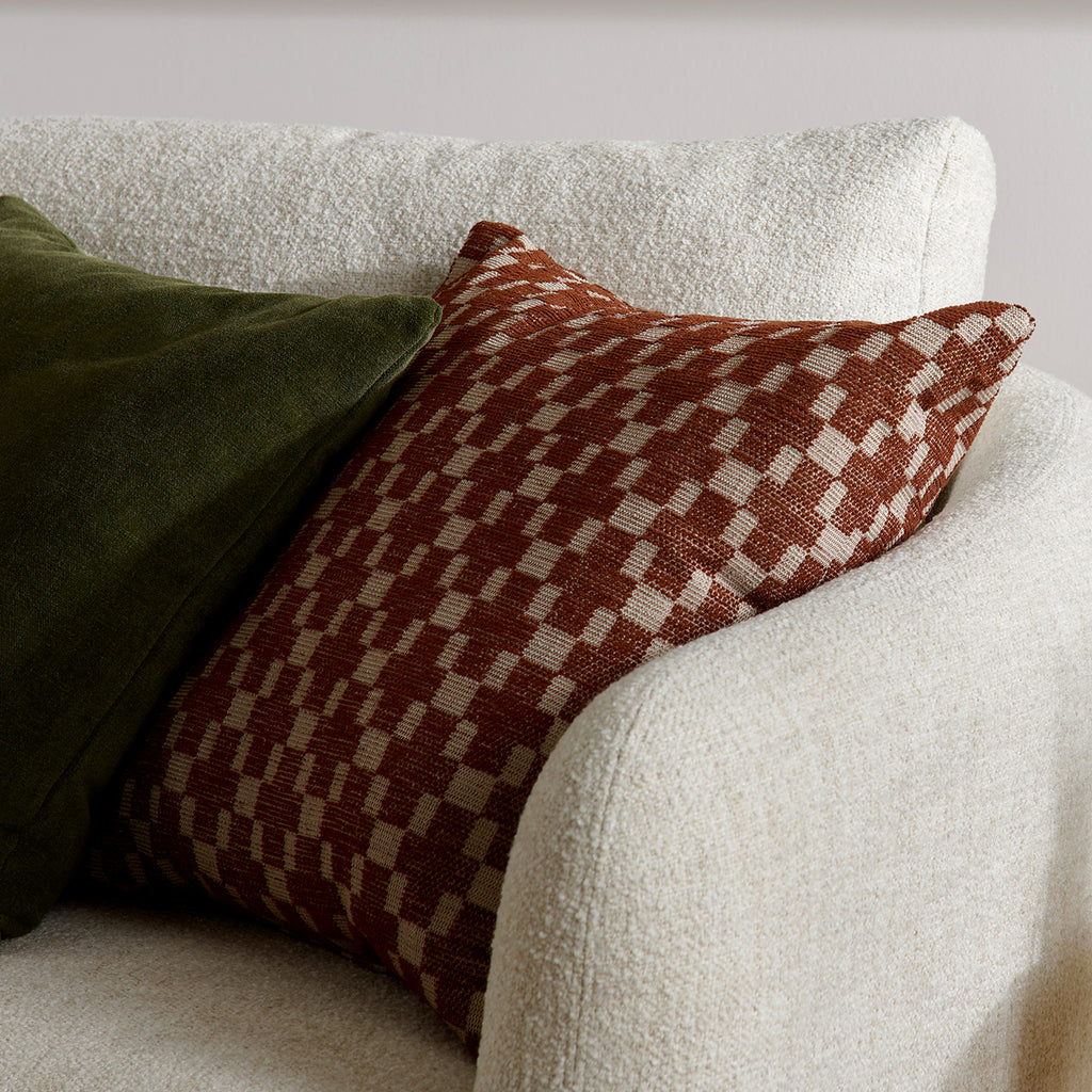 Checkered pillow on a white sofa with a neutral background