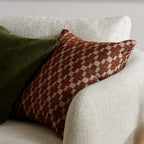 Checkered pillow on a white sofa with a neutral background