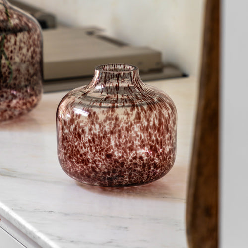 Brown vase on a marble surface with a blurred background