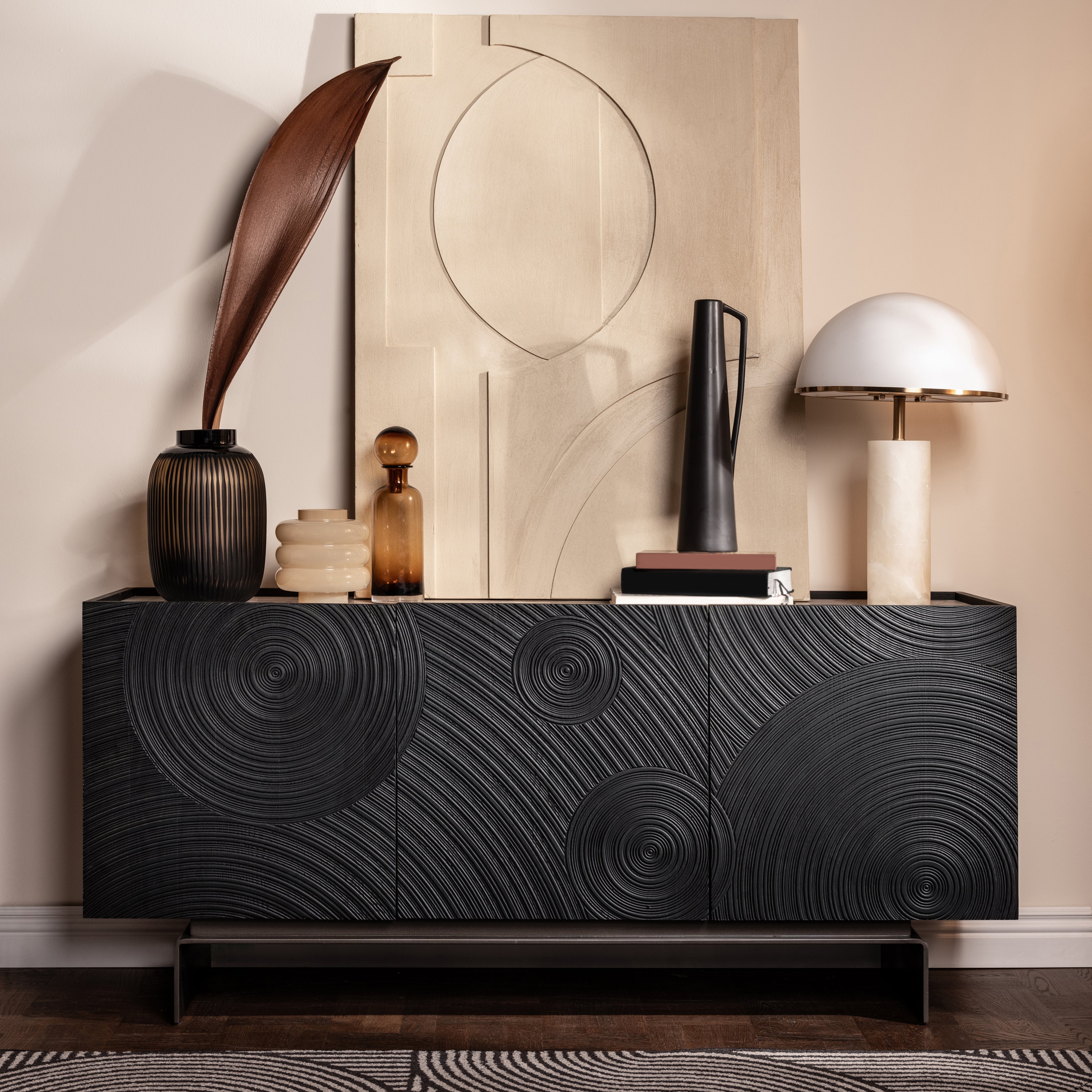 Decorative sideboard with artistic design against a neutral wall. Natural ceramic top.