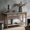 Wallingford 2 Drawer Console Table in a styled entryway setting with decorative items, demonstrating its use as a display surface and storage solution