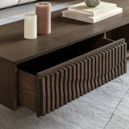 Walnut coffee table with a drawer, candles, and books on top.